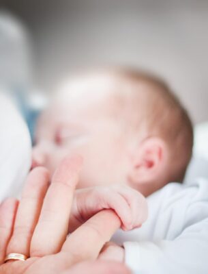 tilt shift lens photo of infant s hand holding index finger 895515
